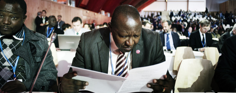 Negotiators look over the new text of the COP21 climate agreement, December 9, 2015. Photo: Benjamin Géminel / COP21