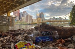 A view of Downtown Pittsburgh from under a bridge with litter.