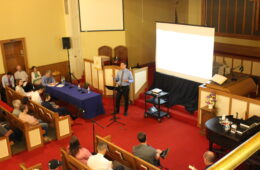 Dr. Arthur Chang in a church, speaking to a crowd