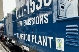 A close-up of the side of the blue electric locomotive with the words "Zero-emissions Clariton Plant."