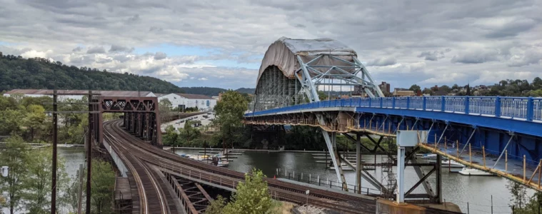 A bridge with railroad bridge next to it crossing a river.