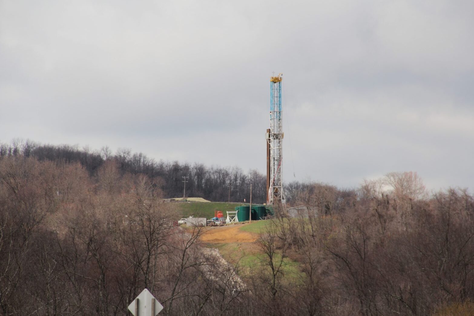 A drilling rig on a hill with trees below