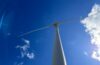 A wind turbine under a blue sky.