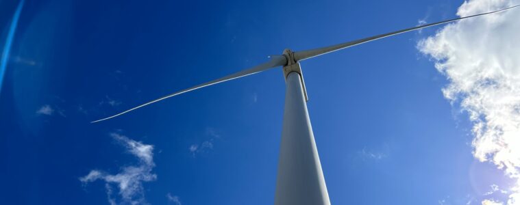 A wind turbine under a blue sky.