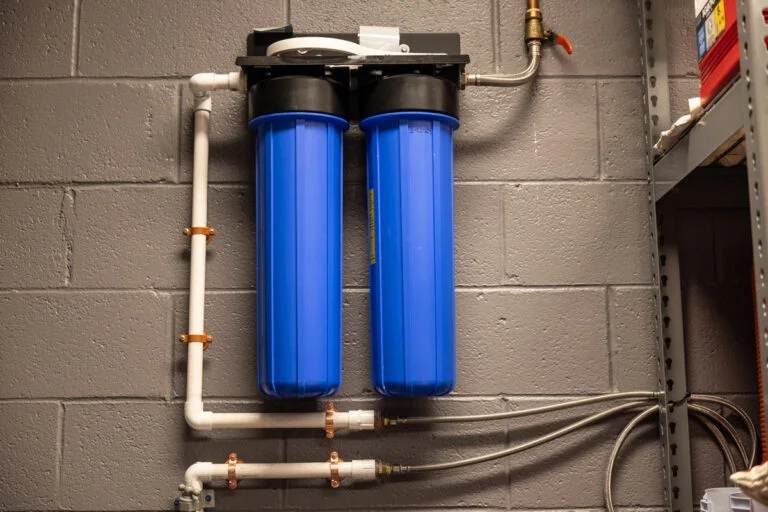 Two blue water filters hanging on a wall