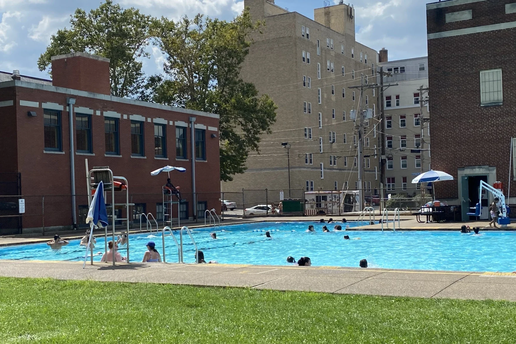 A swimming pool in an urban setting with buildings in the back ground