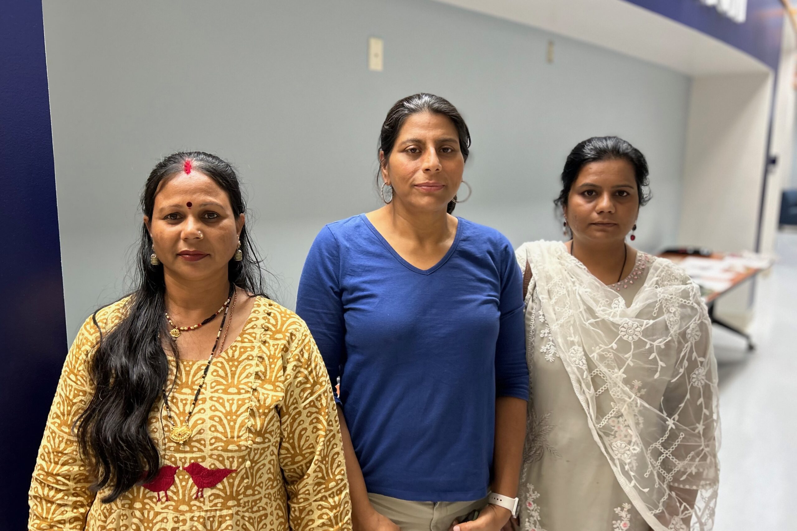 Three women stand together.