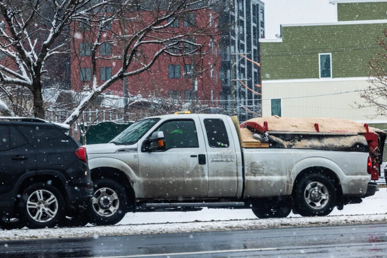 A white pick-up truck on a city street.