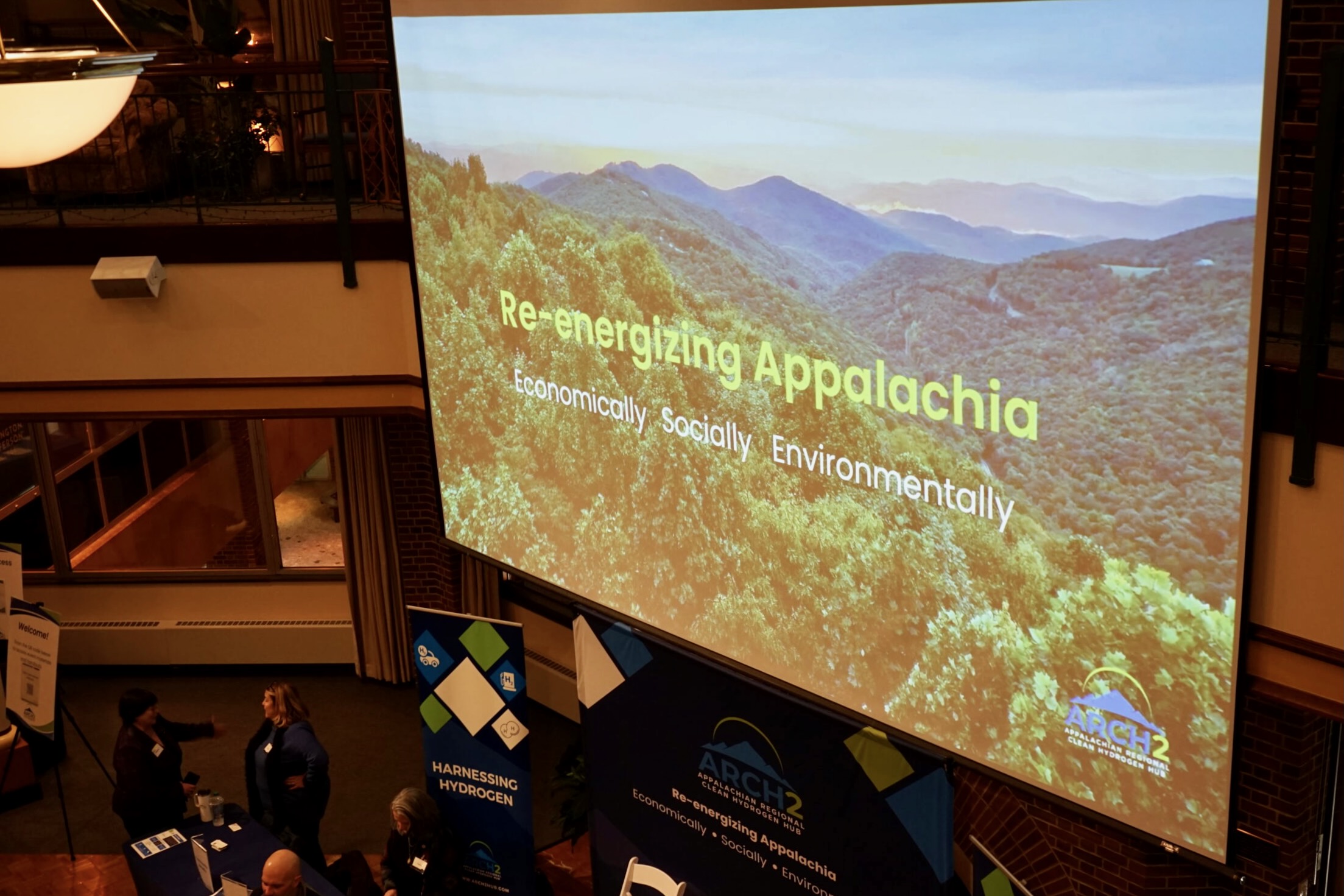 A large screen in front of a rooM that says 'Re-energize Appalachia'