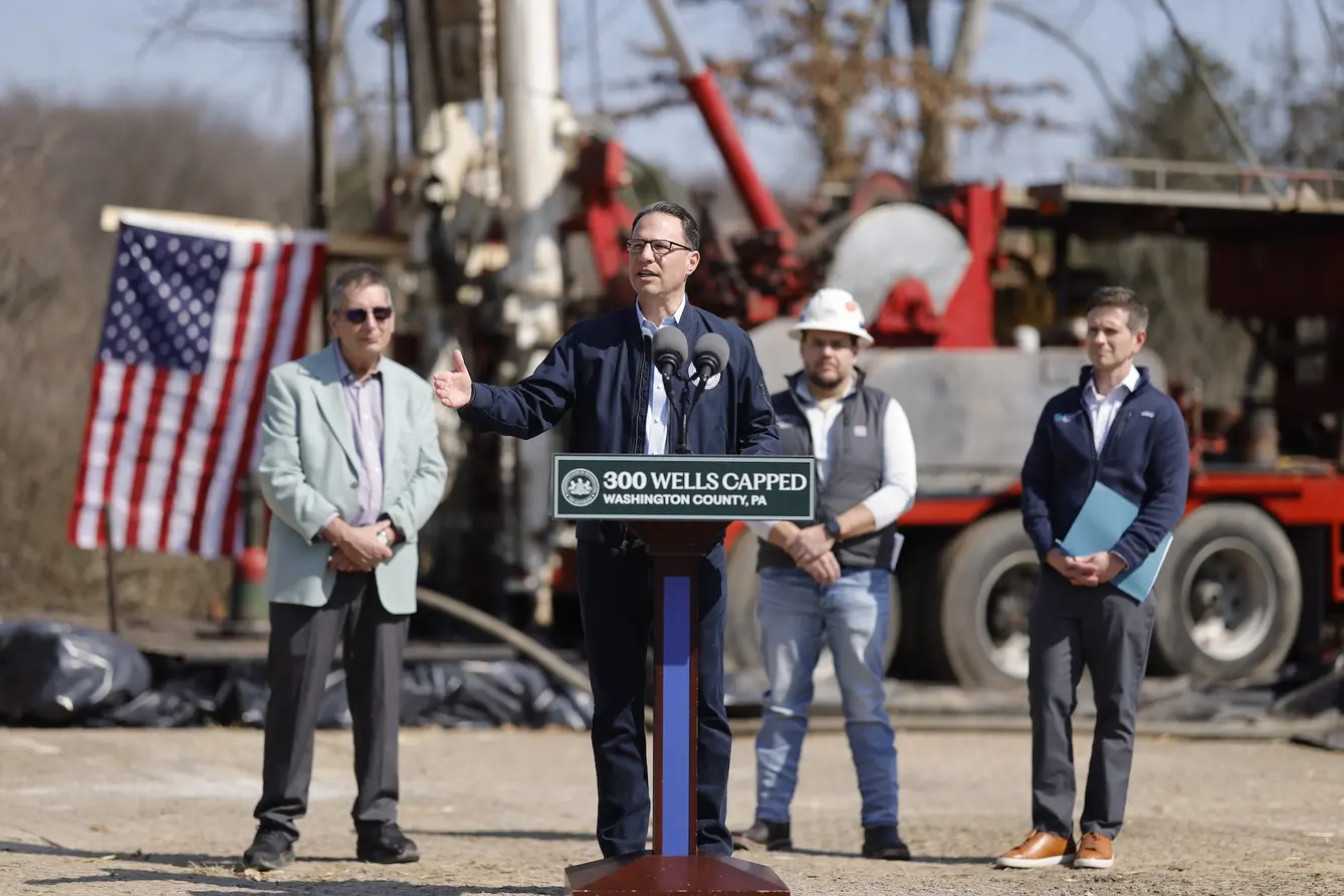 Governor Josh Shapiro speaks at a podium with a sign that reads, "300 wells capped. Washington County, PA.