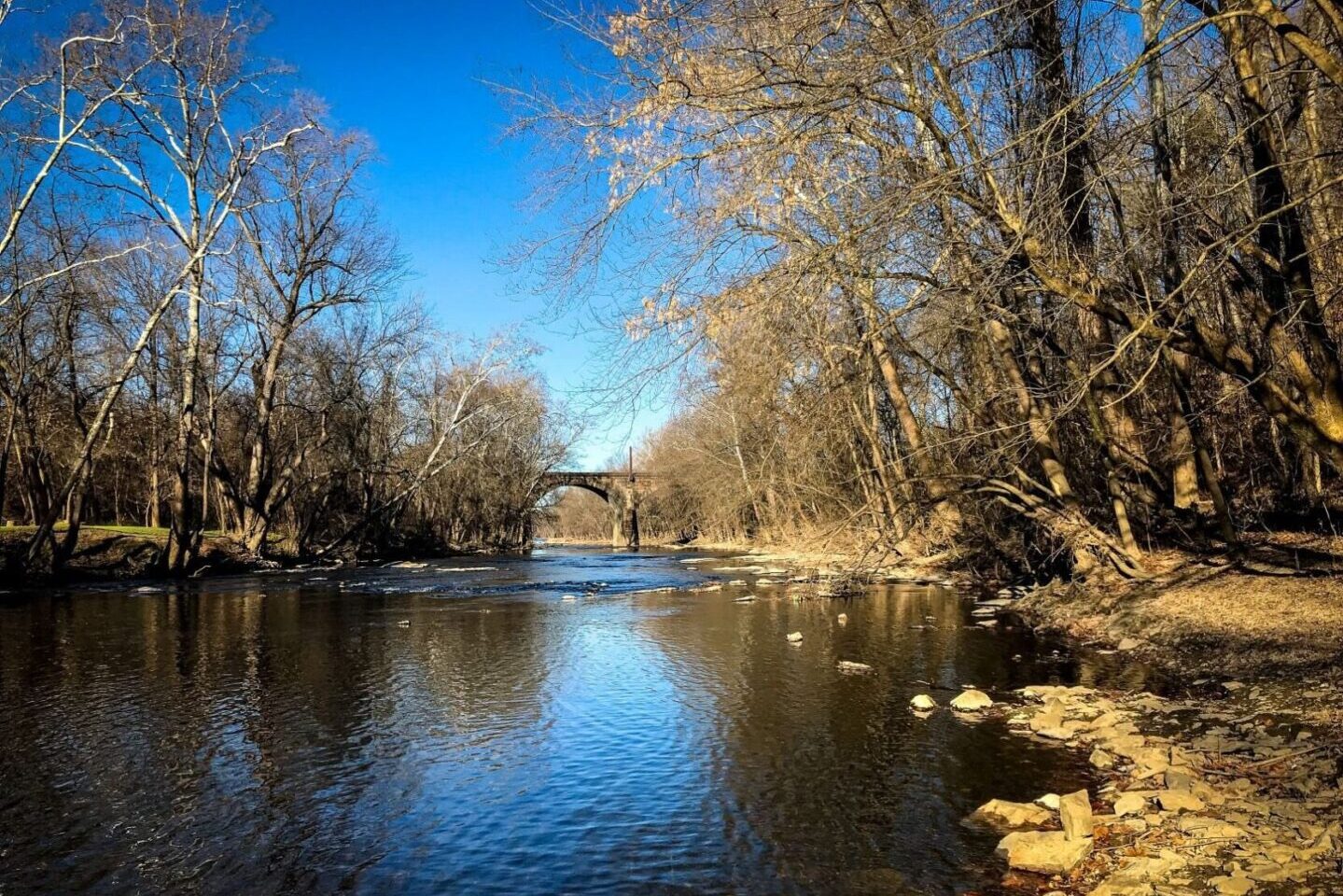 A river waterway with an arched bridge in the distance